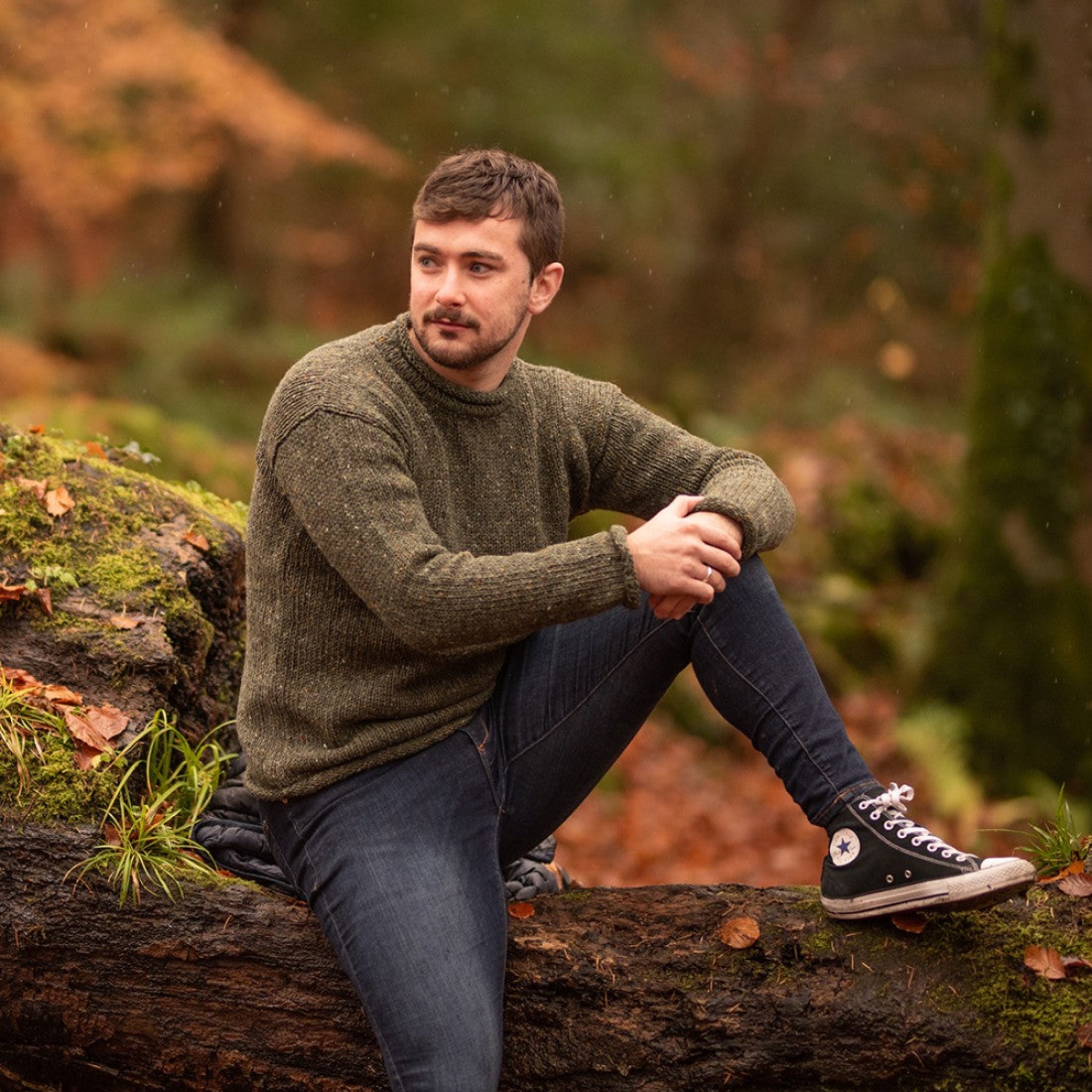 man wearing a moss green wool sweater made in ireland
